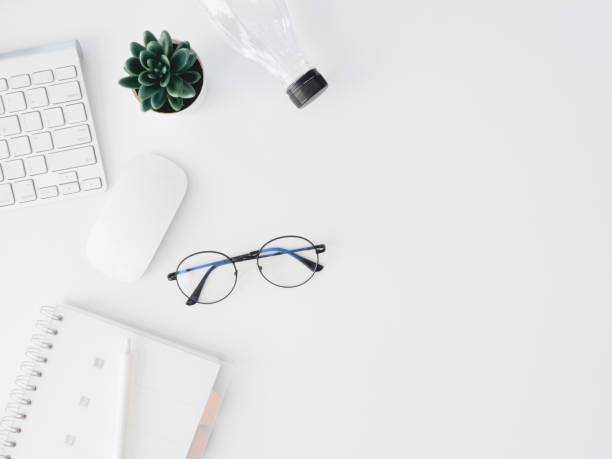 istock top view of office desk table with notebook, plastic plant, digital camera and keyboard on white background, graphic designer, Creative Designer concept. 1180739577