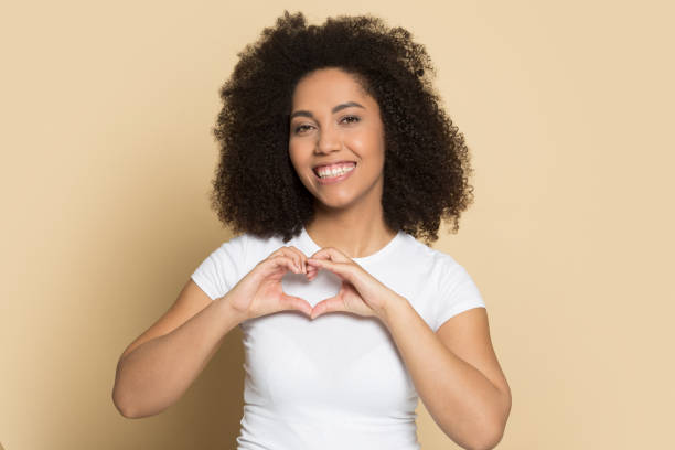 istock Smiling biracial girl look at camera make heart gesture 1180739776
