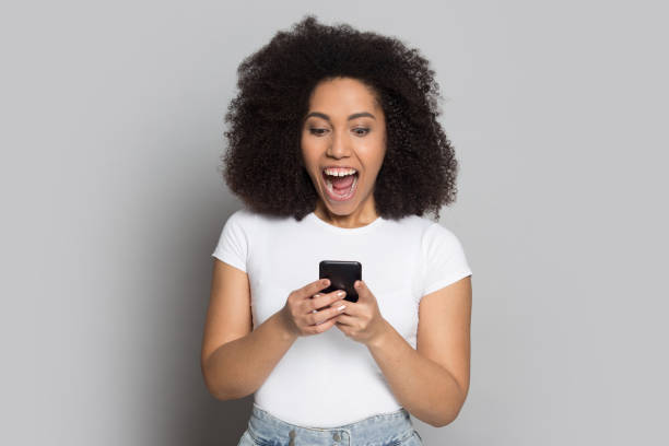 istock Overjoyed biracial girl feel euphoric get message on cell 1180739857