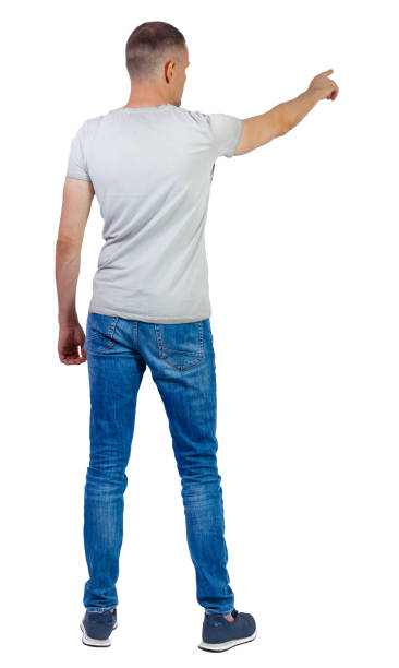 istock Back view of a man in jeans points his hand upwards. 1180745418