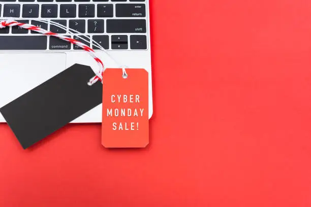 Photo of Online shopping Cyber Monday text with red tag label and Blank black red tag on laptop computer