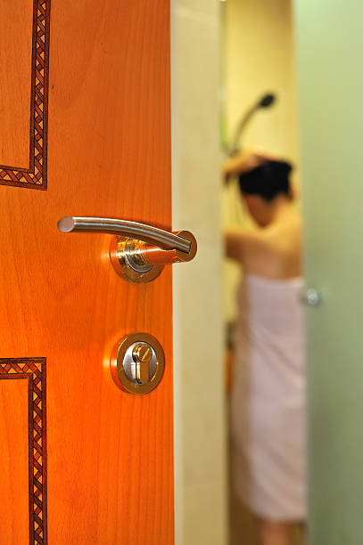peeping a cracked open door to the bath room showing a women about to take or have just finish a bath woman spying through a keyhole stock pictures, royalty-free photos & images