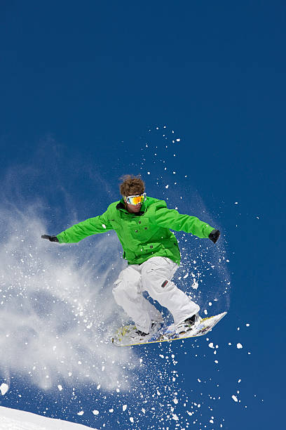 istock Snowboarder Jumping Through Air Against Blue Sky 118074802