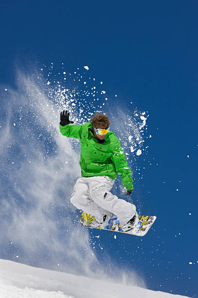 istock Man in green jacket extreme jumping on a snowboard 118074896