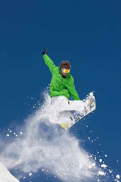 istock Snowboarder Airborne Against Blue Sky and Powder Snow 118074905