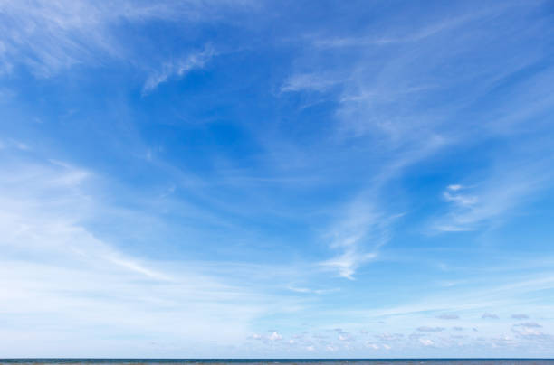 beau ciel bleu au-dessus de la mer avec translucide, blanc, nuages de cirrus - cirrus cloud white fluffy photos et images de collection