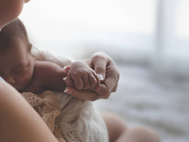 close up mother holding hands asian female newborn baby  and sunlight in the morning. cute little girl  three weeks old. health, care, love, relationship concept. - baby lying down sleeping asian ethnicity imagens e fotografias de stock