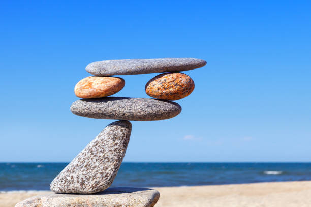 Balanced Rock Zen on the background of the sea. The concept of fall risk and unstable equilibrium. Balanced Rock Zen on the background of the sea. The concept of fall risk and unstable equilibrium unbalance stock pictures, royalty-free photos & images
