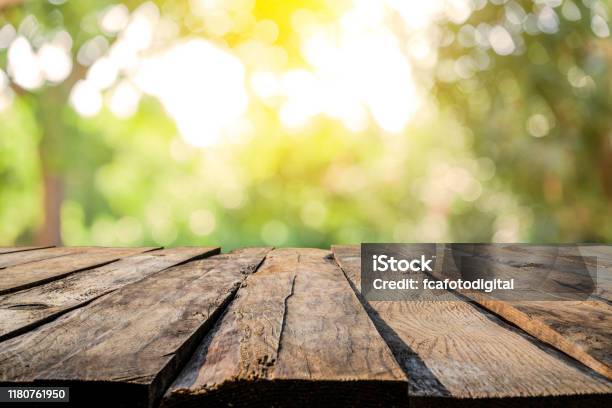 Sfondi Tavolo In Legno Vuoto Con Fogliame Lussureggiante Giallastro Sfocato Sullo Sfondo - Fotografie stock e altre immagini di Tavolo