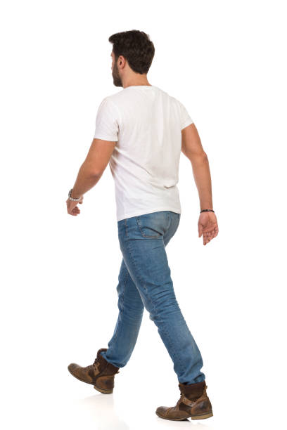 istock Young Man In Jeans And White T-shirt Is Walking. Rear Side View 1180763459