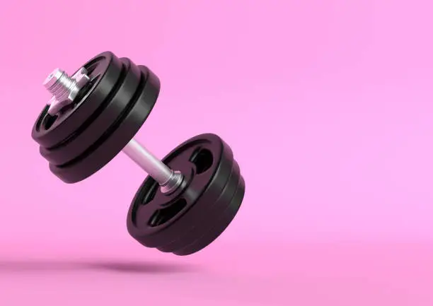 Photo of Dumbbell with black plates levitating in air on bright pink background