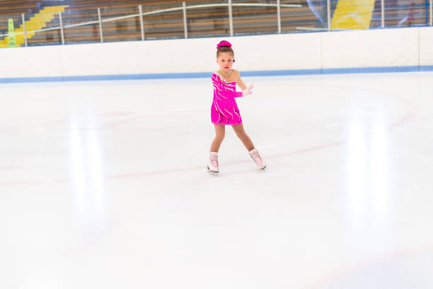 istock Little figure skater in pink dress practicing 1180768379