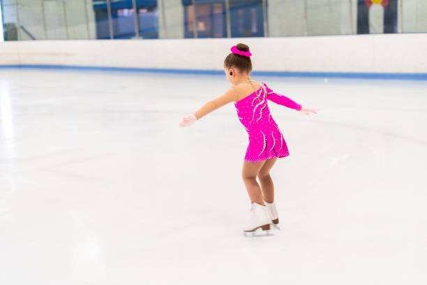 istock Little figure skater in pink dress practicing 1180768407