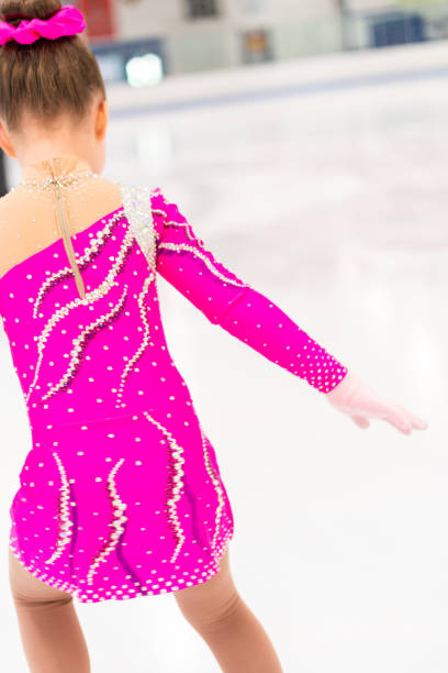 istock Little figure skater in pink dress practicing 1180768454