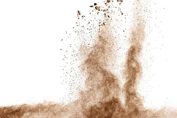 Photo of Brown dust explosion cloud.Brown particles splatter on white background.