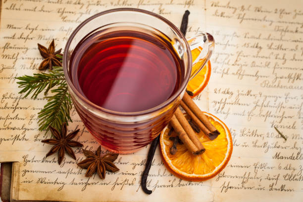 Hot spiced wine with spices on an old cookbook from above
