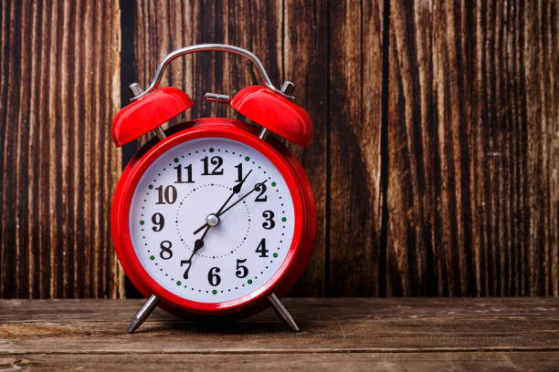 istock Red alarm clock on wooden table, time to wake up 1180769494