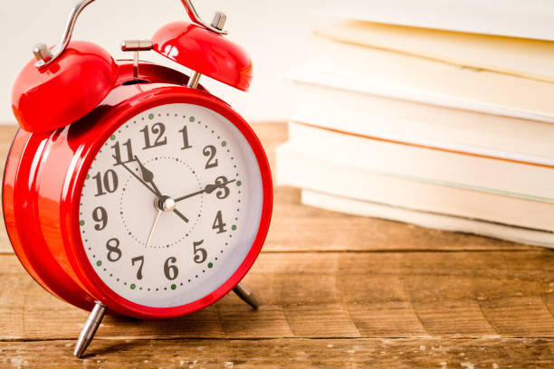 istock Alarm clock and stack of books. 1180771130