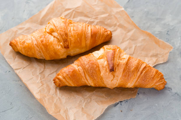 istock Croissants with paper on a gray concrete background. View from above. Top view. 1180774986