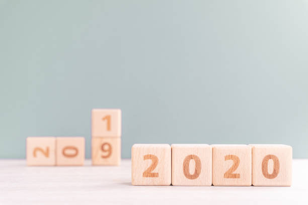istock Abstract 2020, 2019 New year target plan design concept - wood blocks cubes on wooden table and pastel green background. 1180777183
