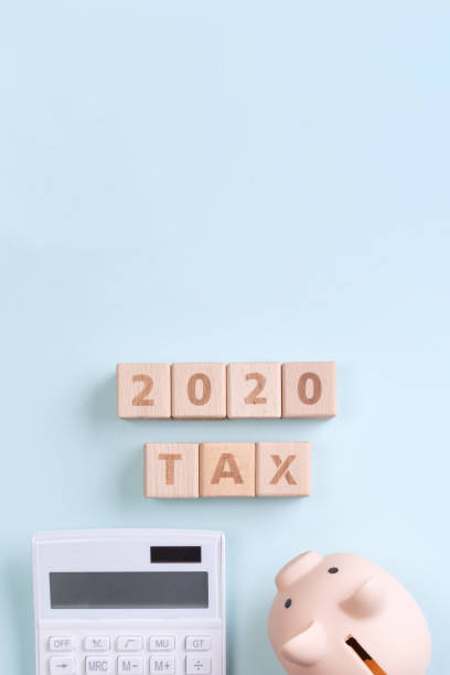 istock 2020 goal, finance plan abstract design concept, wood blocks on blue table background with piggy bank and calculator. 1180777189