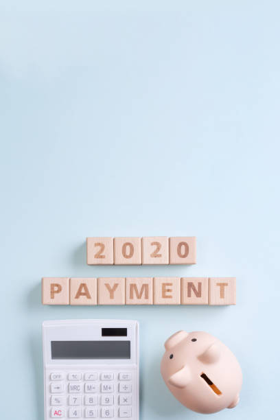 istock 2020 goal, finance plan abstract design concept, wood blocks on blue table background with piggy bank and calculator. 1180777190