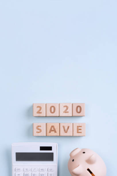 istock 2020 goal, finance plan abstract design concept, wood blocks on blue table background with piggy bank and calculator. 1180777207