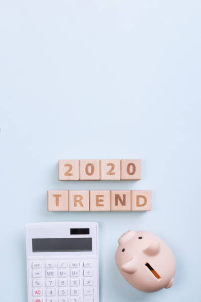 istock 2020 goal, finance plan abstract design concept, wood blocks on blue table background with piggy bank and calculator. 1180777214
