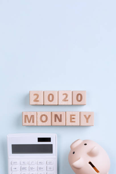istock 2020 goal, finance plan abstract design concept, wood blocks on blue table background with piggy bank and calculator. 1180777239