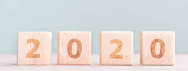 istock Abstract 2020, 2019 New year target plan design concept - wood blocks cubes on wooden table and pastel green background. 1180777276