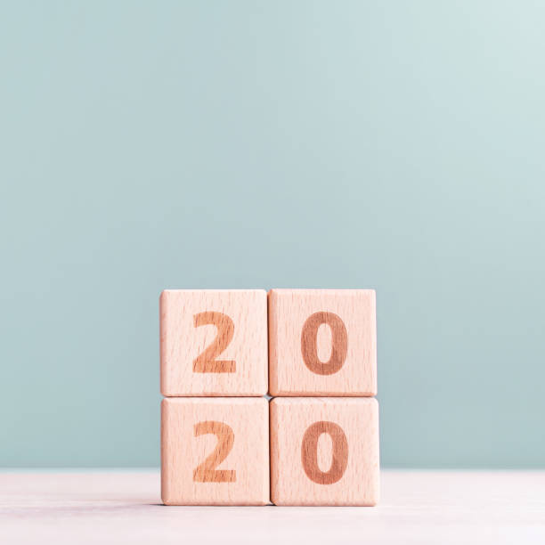 istock Abstract 2020, 2019 New year target plan design concept - wood blocks cubes on wooden table and pastel green background. 1180777281