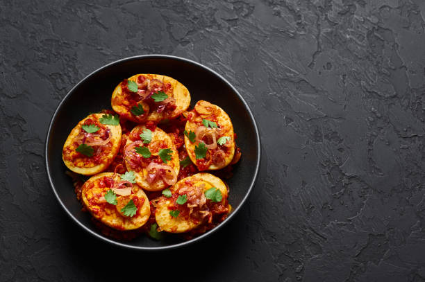 istock Golden Egg Curry in black bowl at dark slate background. Burmese Egg Curry is popular Myanmar Cuisine dish with duck or chicken eggs, tomatoes, ginger, onion, cilantro and spices. 1180778023