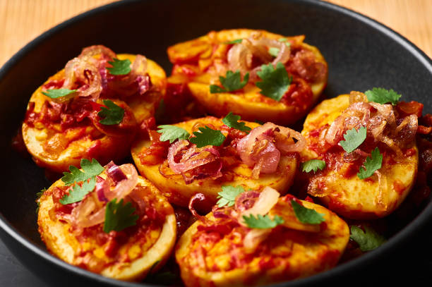 istock Golden Egg Curry in black bowl at dark slate background. Burmese Egg Curry is popular Myanmar Cuisine dish with duck or chicken eggs, tomatoes, ginger, onion, cilantro and spices. 1180778318