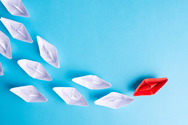 istock red paper ship as a leader. Blue background. . Copy space 1180778974
