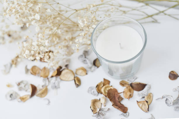 istock Candle with floral decor on a white table. Cozy and hygge background 1180779509
