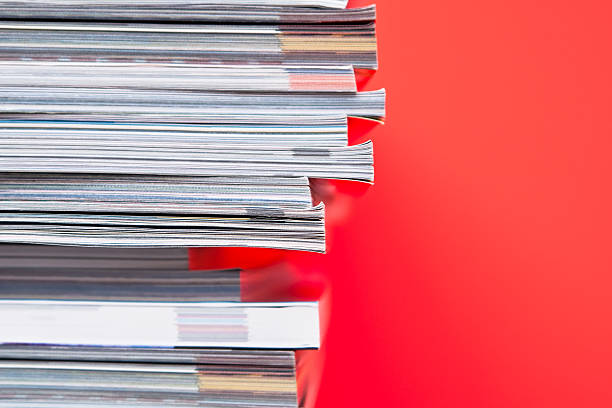 Stack of magazines set in front of red wall