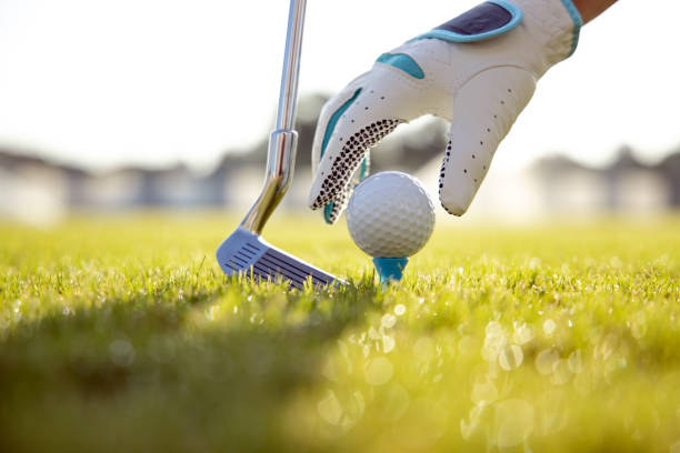 istock Hand in glove placing golf ball on tee 1180780610