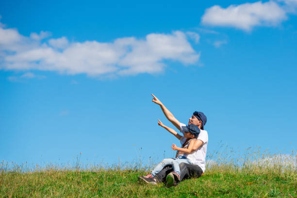 istock Father and daughter sitting in the meadow 1180784275