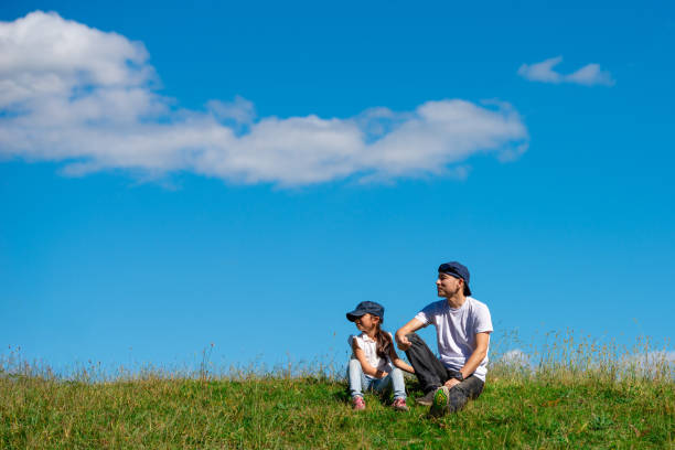 Father and daughter sitting in the meadow