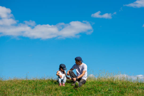 Father and daughter sitting in the meadow