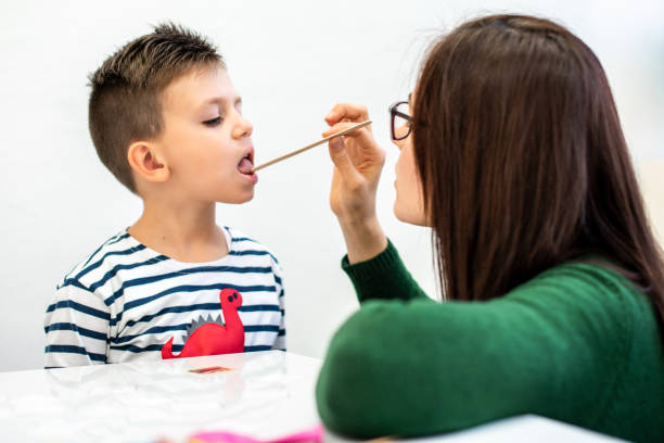istock Children speech therapy concept. Preschooler practicing correct pronunciation with a female speech therapist. 1180785222