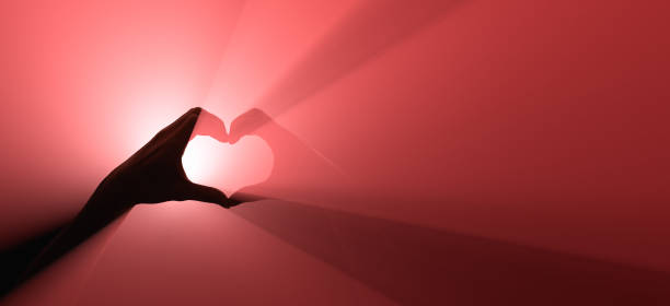 gesto de mão. símbolo do amor. projector vermelho no fundo. - valentines day hearts flash - fotografias e filmes do acervo