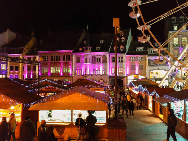 panoramablick auf den farbigen traditionellen weihnachtsmarkt auf dem hauptplatz von mulhouse (alsace, frankreich) bei nacht - mühlhausen stock-fotos und bilder