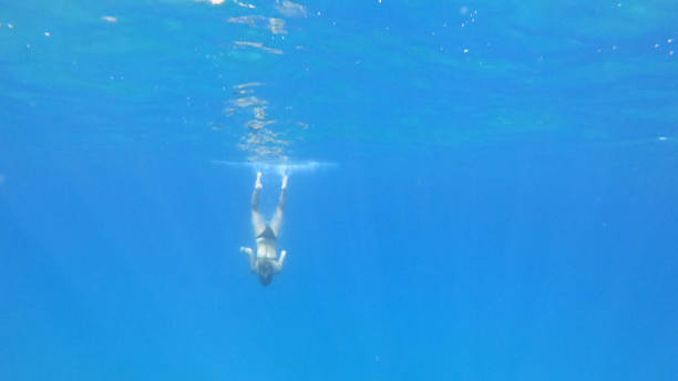 istock Young woman explores the sea underwater 1180787818