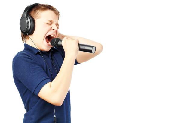 istock Teenage boy singing into a microphone. Very emotional. 1180788071