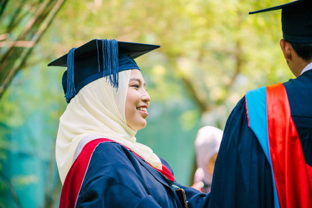 istock Sister Helping Brother with His Graduation Gown 1180788162