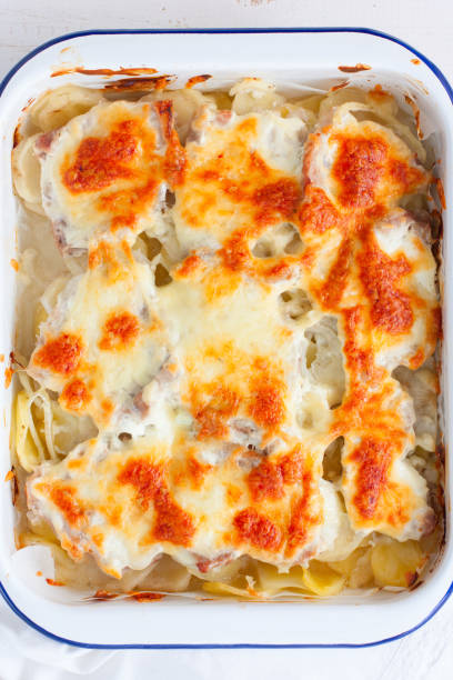 istock Baked sliced potatoes with pork and cheese, top view, selective focus 1180790038
