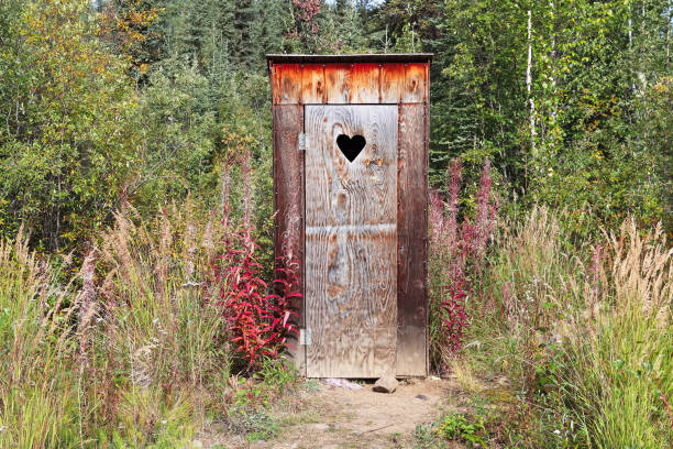 An outhouse in a wooded area with a heart window An outhouse in a wooded area with a heart window. Outhouse stock pictures, royalty-free photos & images