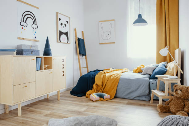 istock Stylish wooden commode in bright bedroom interior with poster on the wall 1180791691