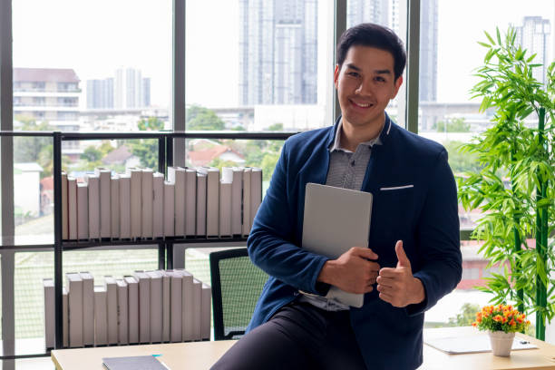 istock A young Asian businessman with a notebook And smile in the office 1180792473